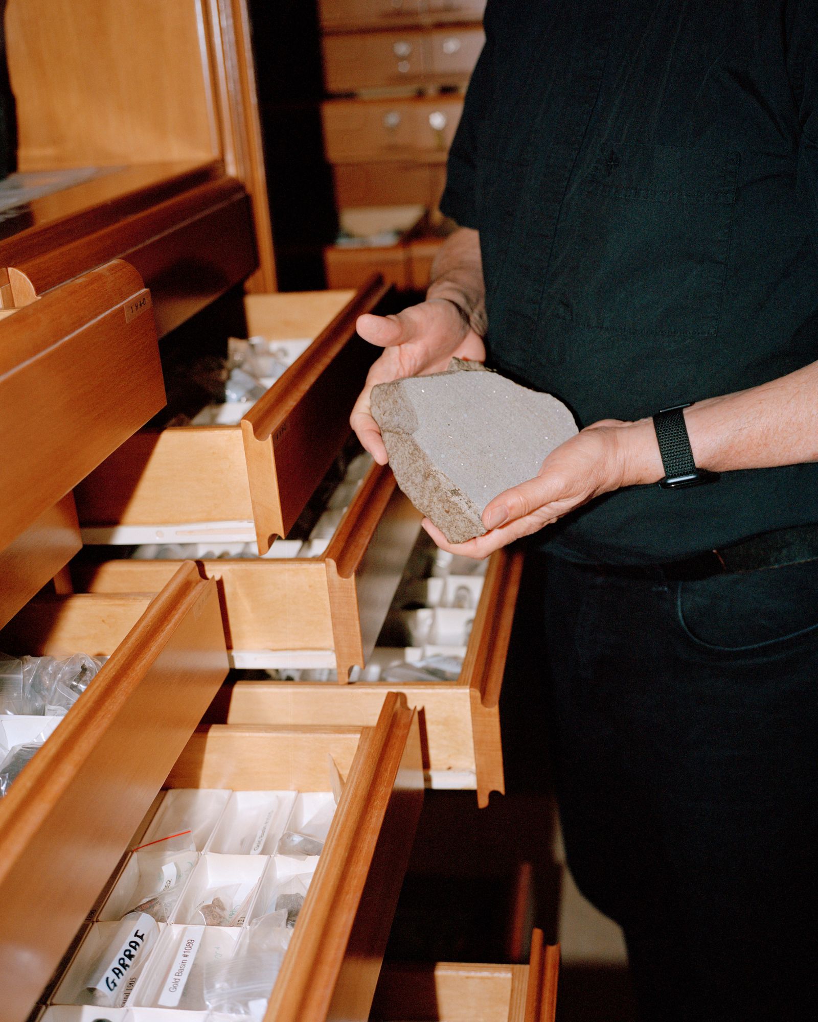 A man holds a specimen from a meteorite.