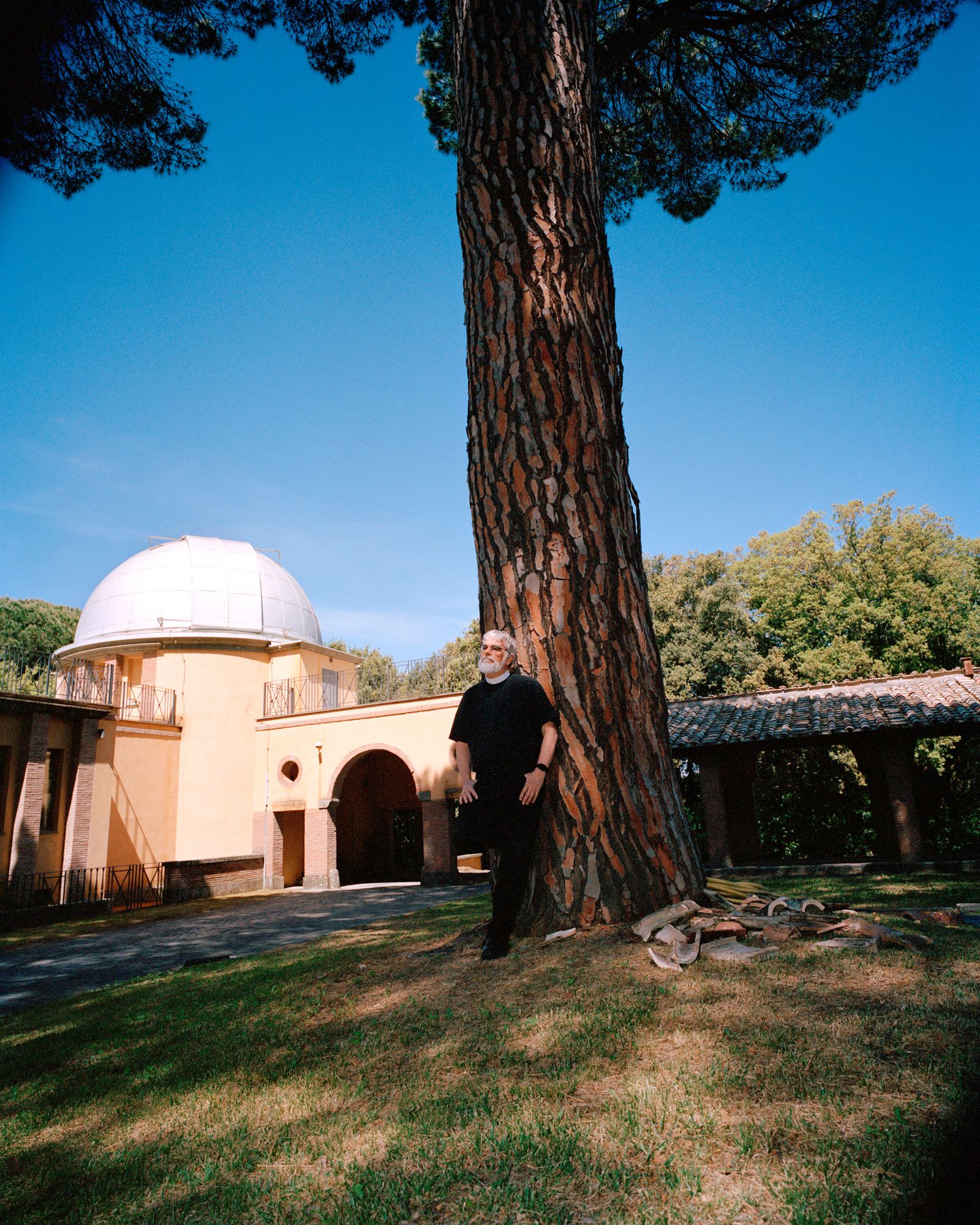 A man leans against a tree.